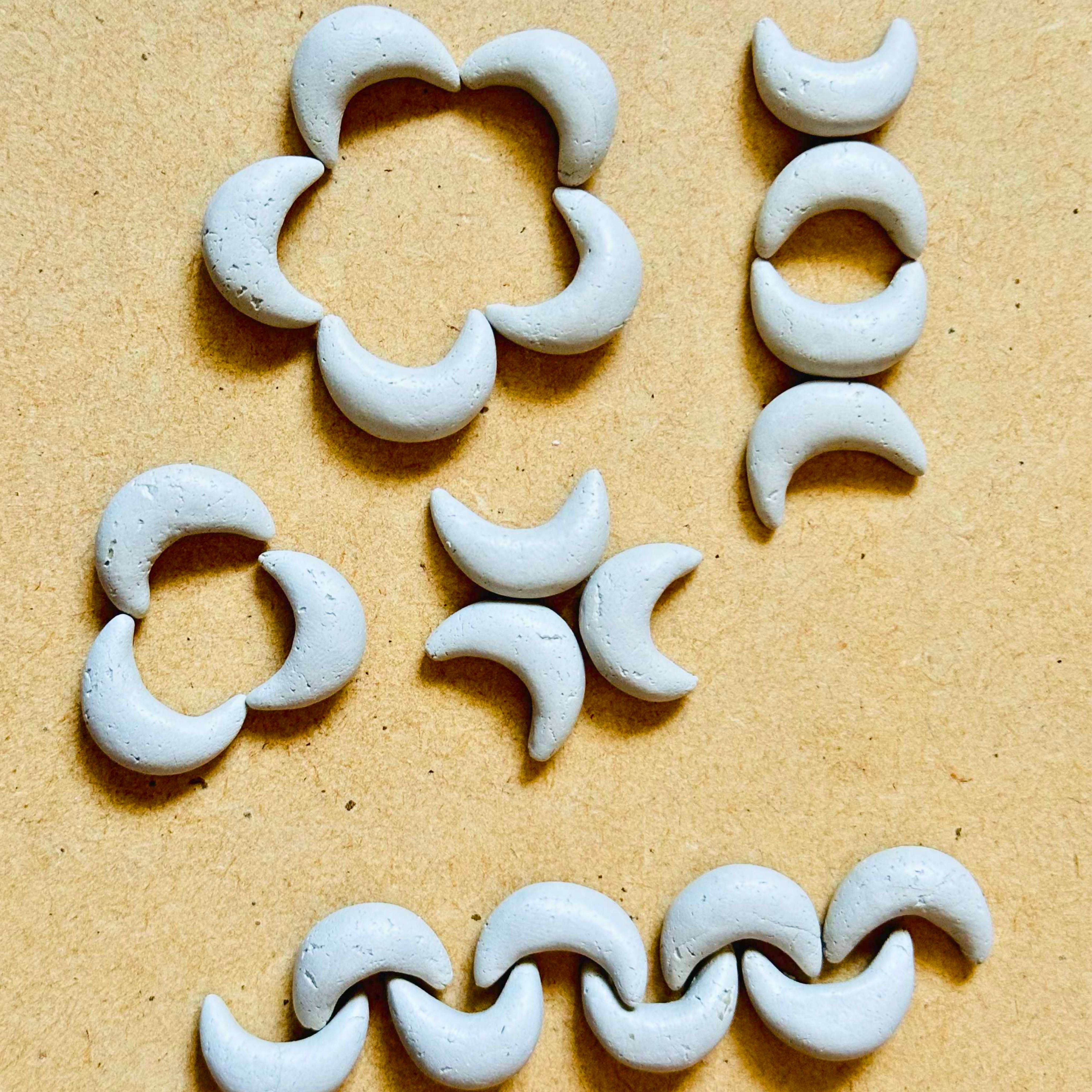Crescent moon shape mirror pieces arranged in floral and border patterns for Lippan art, mirror work, and DIY craft decoration.