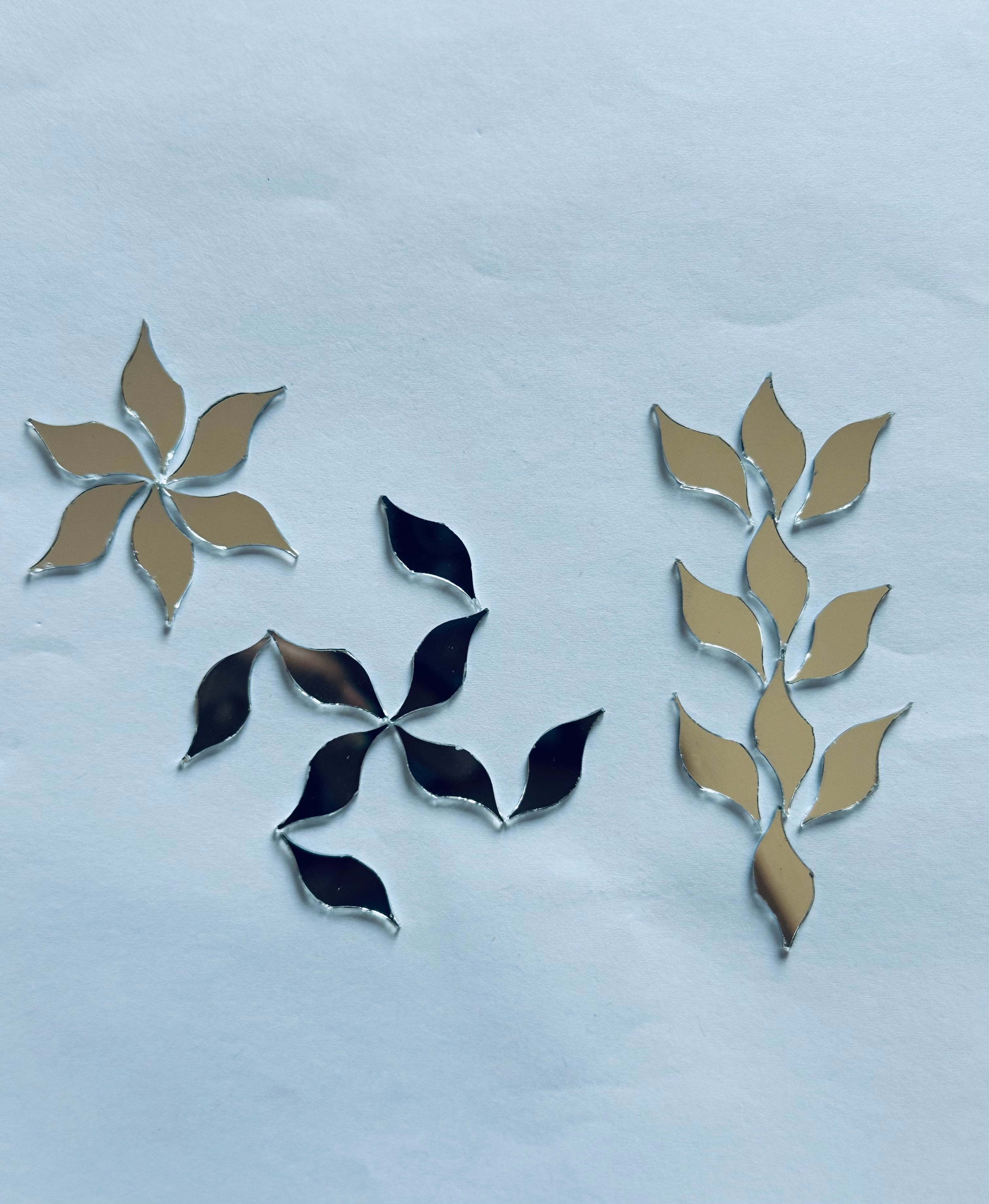Golden leaf shape mirror pieces arranged in floral patterns for Lippan art and Mandala craft