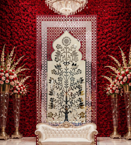 Elegant floral mirror wall panel with traditional arch design and intricate silver mirror detailing on a pink decorative frame.
